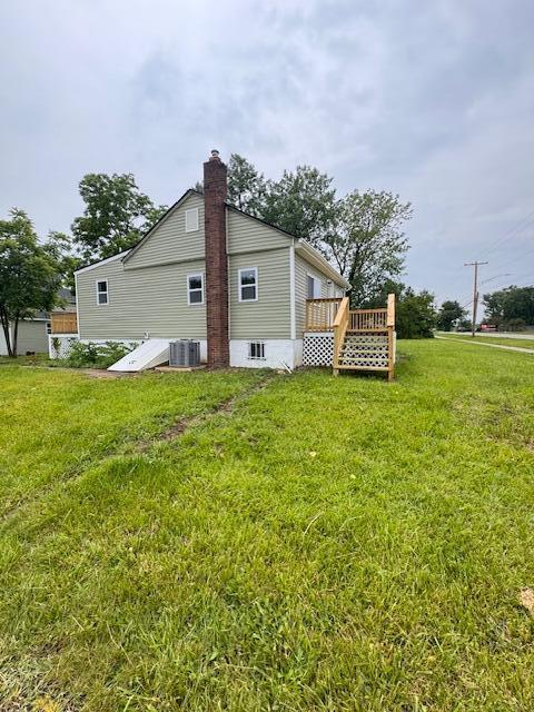 1729 E 17th Ave, Columbus, OH 43219 - view of side of home with a lawn, central AC unit, a deck, and a chimney