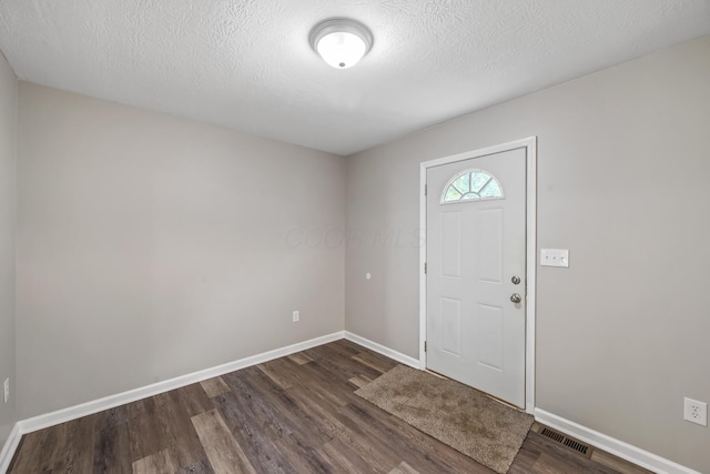 845 Bennett St, Marion, OH 43302 - foyer entrance with dark wood-type flooring, baseboards, and a textured ceiling