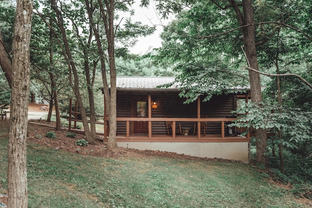 16360 Kreashbaum Rd, Rockbridge, OH 43149 - back of house with covered porch, log veneer siding, a lawn, and metal roof