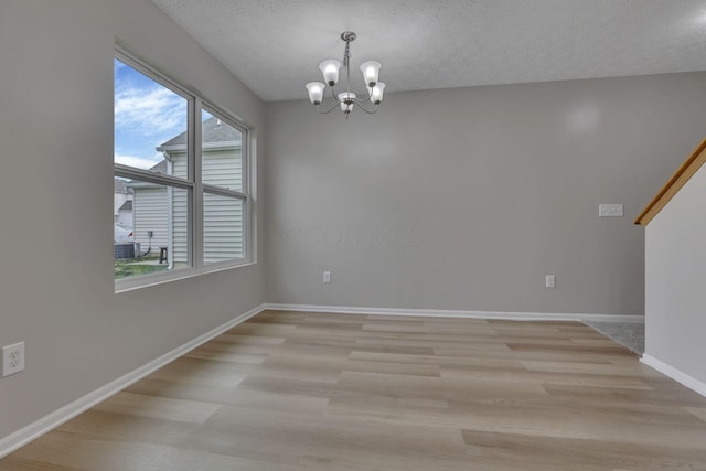 2563 Bristlecone Ln, Grove City, OH 43123 - spare room featuring a chandelier, light wood-type flooring, a textured ceiling, and baseboards
