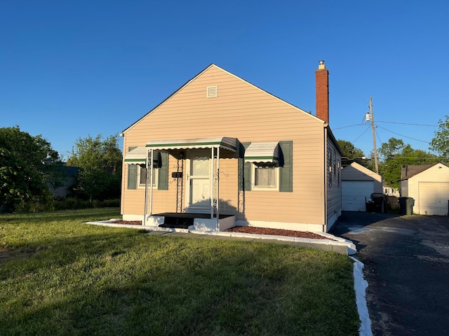 2296 Joyce Ave, Columbus, OH 43211 - view of front of house featuring a chimney, a front yard, a garage, and an outdoor structure