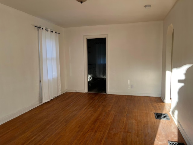 2296 Joyce Ave, Columbus, OH 43211 - spare room featuring wood finished floors, baseboards, a smoke detector, and arched walkways