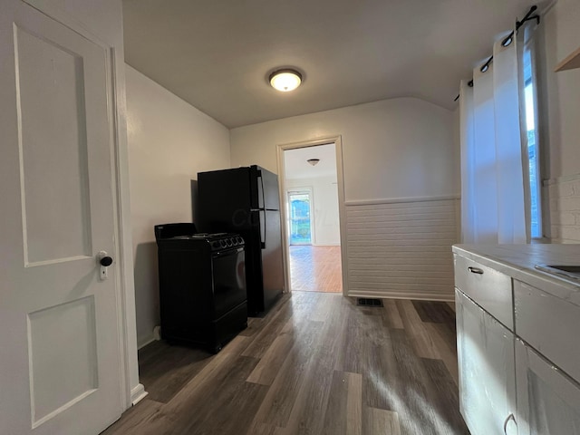 2296 Joyce Ave, Columbus, OH 43211 - kitchen with black appliances, dark wood-style floors, lofted ceiling, white cabinetry, and tile countertops