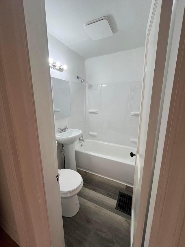 2296 Joyce Ave, Columbus, OH 43211 - bathroom featuring wood finished floors, toilet, shower / tub combination, and a sink