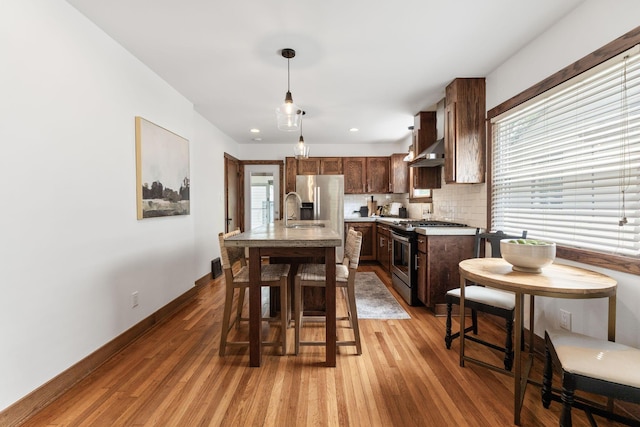 525 E Como Ave, Columbus, OH 43202 - kitchen with stainless steel appliances, ventilation hood, backsplash, wood finished floors, and recessed lighting