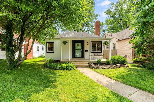 525 E Como Ave, Columbus, OH 43202 - bungalow with covered porch, a front lawn, a chimney, board and batten siding, and a shingled roof