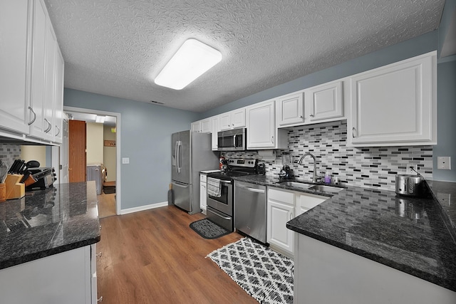 4654 Collingville Way, Columbus, OH 43230 - kitchen featuring stainless steel appliances, a sink, wood finished floors, white cabinetry, and a textured ceiling