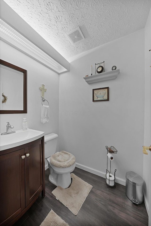 4654 Collingville Way, Columbus, OH 43230 - half bathroom with vanity, wood finished floors, toilet, and baseboards