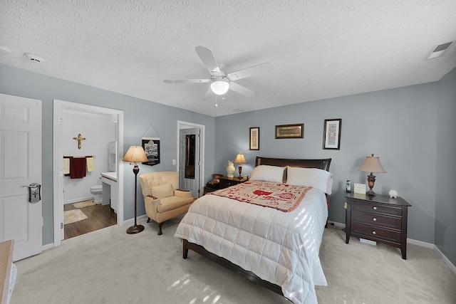 4654 Collingville Way, Columbus, OH 43230 - bedroom featuring light colored carpet, a textured ceiling, connected bathroom, baseboards, and ceiling fan