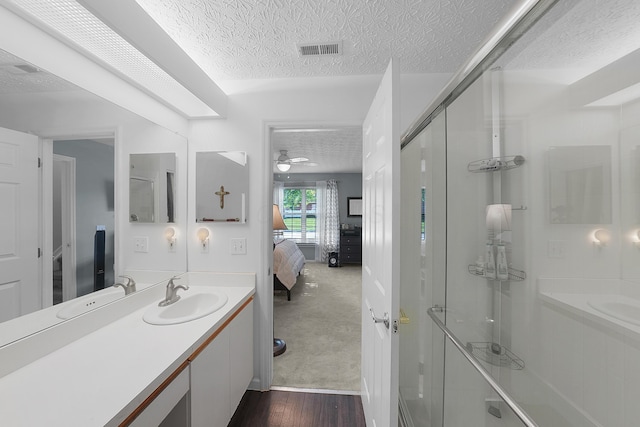 4654 Collingville Way, Columbus, OH 43230 - ensuite bathroom featuring a textured ceiling, a stall shower, vanity, a ceiling fan, and wood finished floors