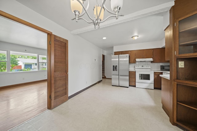 5754 Loganwood Rd, Columbus, OH 43229 - kitchen featuring electric range, stainless steel fridge, under cabinet range hood, black microwave, and light countertops