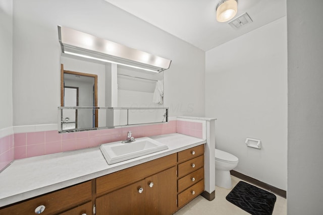 5754 Loganwood Rd, Columbus, OH 43229 - bathroom featuring toilet, backsplash, vanity, and baseboards