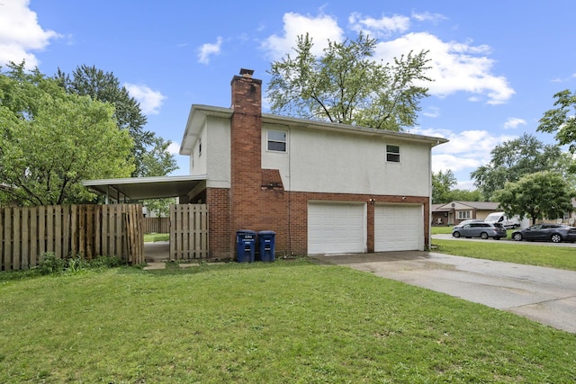 5754 Loganwood Rd, Columbus, OH 43229 - view of side of home featuring a garage, driveway, a chimney, brick siding, and stucco siding