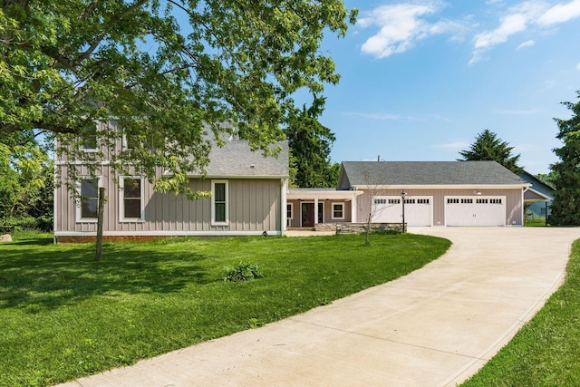 6900 Waterloo Rd NW, Canal Winchester, OH 43110 - view of front facade with board and batten siding, concrete driveway, a front yard, an attached garage, and a shingled roof