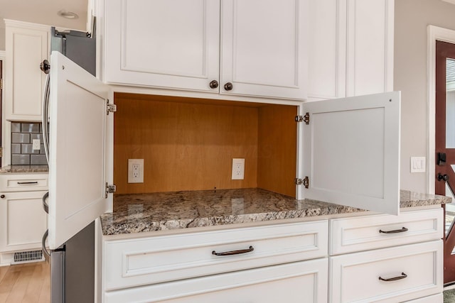 6900 Waterloo Rd NW, Canal Winchester, OH 43110 - kitchen with white cabinets, decorative backsplash, light stone countertops, and light wood-style floors