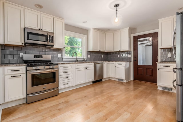 6900 Waterloo Rd NW, Canal Winchester, OH 43110 - kitchen featuring stainless steel appliances, backsplash, white cabinets, and light stone countertops