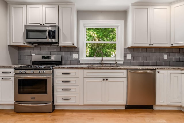 6900 Waterloo Rd NW, Canal Winchester, OH 43110 - kitchen with appliances with stainless steel finishes, dark stone counters, tasteful backsplash, and white cabinetry