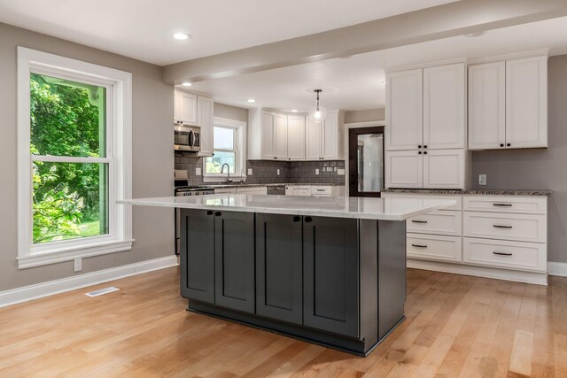 6900 Waterloo Rd NW, Canal Winchester, OH 43110 - kitchen with stainless steel appliances, white cabinetry, light wood-style flooring, a kitchen island, and recessed lighting