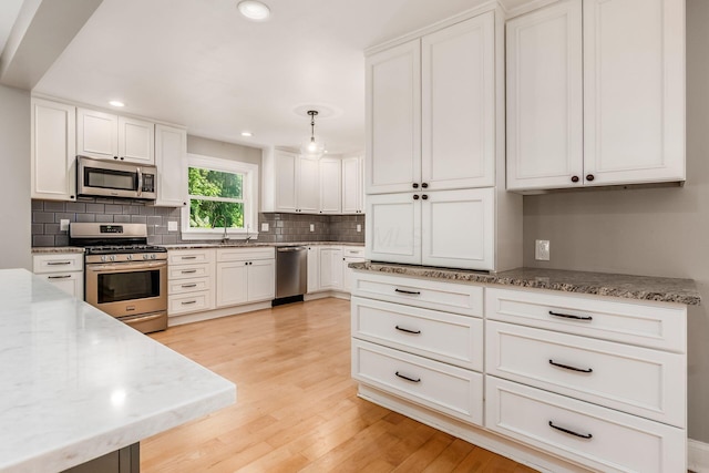 6900 Waterloo Rd NW, Canal Winchester, OH 43110 - kitchen with stainless steel appliances, backsplash, light wood finished floors, white cabinetry, and recessed lighting