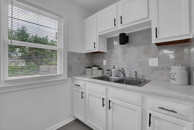 2217 Grasmere Ave, Columbus, OH 43211 - kitchen with a sink, plenty of natural light, decorative backsplash, and white cabinetry