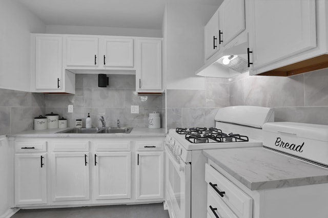 2217 Grasmere Ave, Columbus, OH 43211 - kitchen with white gas stove, a sink, white cabinetry, and backsplash