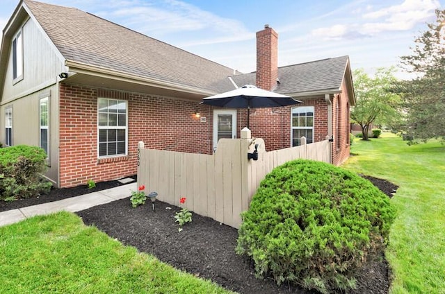 560 Dandy Brush Ln E, Columbus, OH 43230 - view of property exterior featuring brick siding, a shingled roof, and a chimney