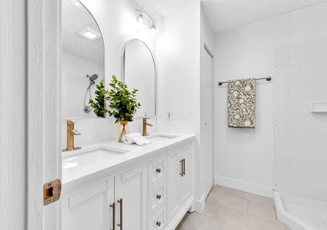 560 Dandy Brush Ln E, Columbus, OH 43230 - full bath with double vanity, tiled shower, tile patterned floors, and baseboards