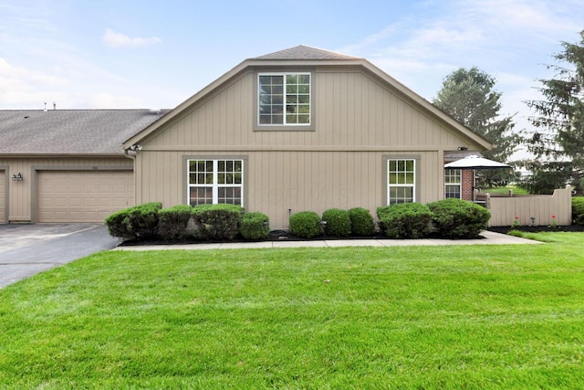560 Dandy Brush Ln E, Columbus, OH 43230 - view of side of home featuring driveway, a yard, and a garage