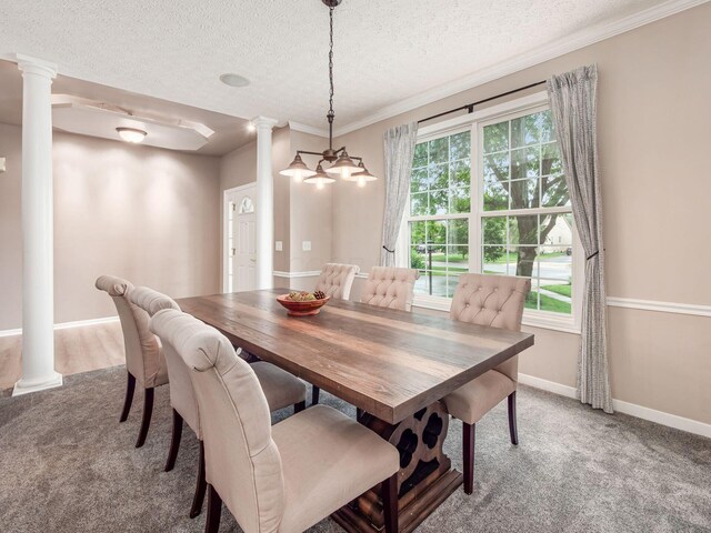 7034 Kellogg Dr, Powell, OH 43065 - dining room featuring ornate columns, light carpet, a textured ceiling, baseboards, and crown molding
