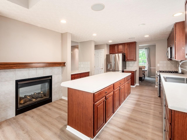 7034 Kellogg Dr, Powell, OH 43065 - kitchen featuring stainless steel appliances, light wood finished floors, a kitchen island, light countertops, and recessed lighting