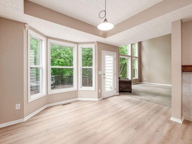 7034 Kellogg Dr, Powell, OH 43065 - spare room with a textured ceiling, baseboards, light wood finished floors, and a raised ceiling