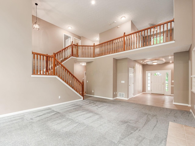 7034 Kellogg Dr, Powell, OH 43065 - unfurnished living room with carpet flooring, stairs, baseboards, a towering ceiling, and recessed lighting