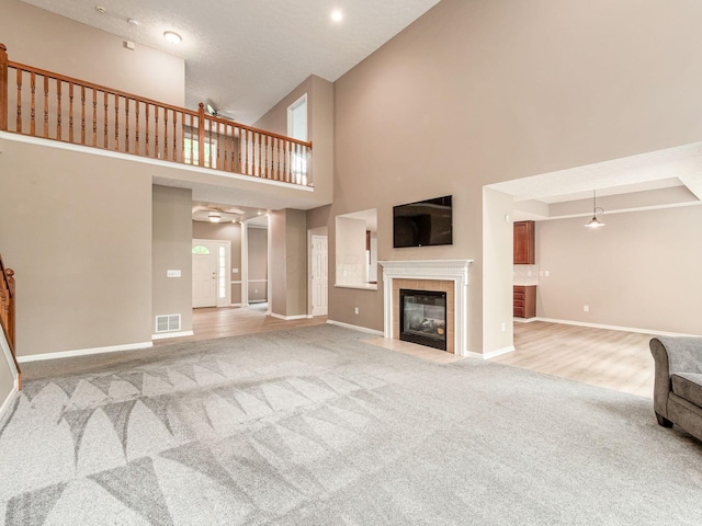 7034 Kellogg Dr, Powell, OH 43065 - unfurnished living room featuring light carpet, high vaulted ceiling, baseboards, and a tiled fireplace