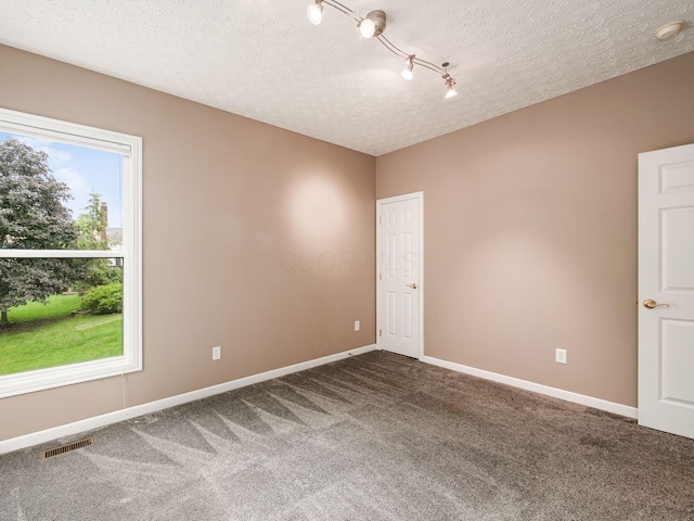 7034 Kellogg Dr, Powell, OH 43065 - spare room featuring dark carpet, baseboards, a textured ceiling, and a smoke detector