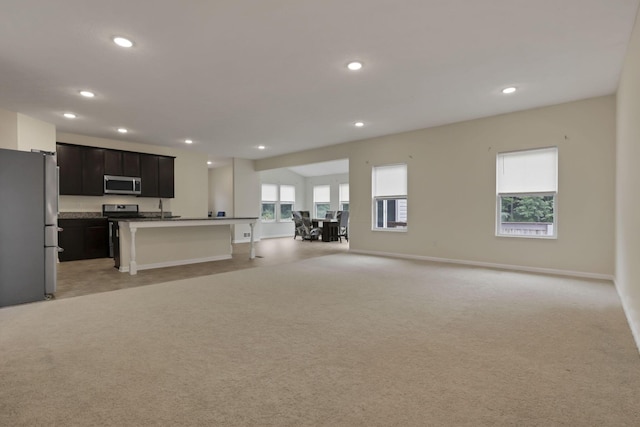1137 Legacy Ln, Pataskala, OH 43062 - kitchen with appliances with stainless steel finishes, open floor plan, light colored carpet, recessed lighting, and a breakfast bar