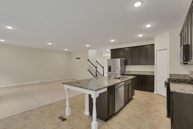 1137 Legacy Ln, Pataskala, OH 43062 - kitchen with stainless steel appliances, a sink, a kitchen island with sink, a breakfast bar area, and dark brown cabinets