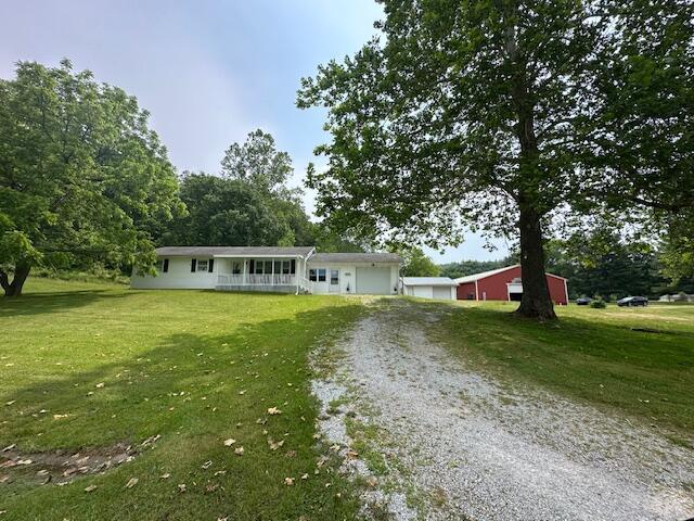 14572 Hock Hocking Rd, Logan, OH 43138 - ranch-style home featuring driveway, a front lawn, covered porch, and an attached garage