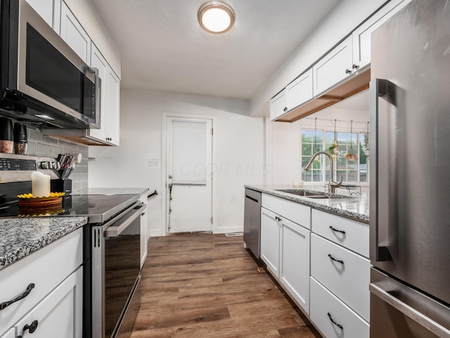 334 Wittenberg St, Columbus, OH 43230 - kitchen with appliances with stainless steel finishes, a sink, backsplash, white cabinets, and dark wood-style flooring