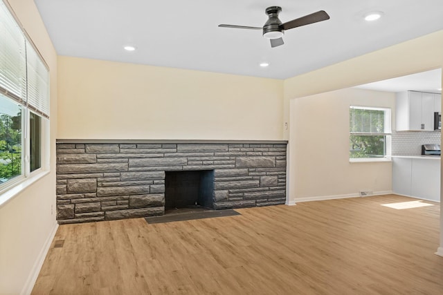 1345 E Deshler Ave, Columbus, OH 43206 - unfurnished living room featuring a fireplace, baseboards, light wood-style floors, a ceiling fan, and recessed lighting