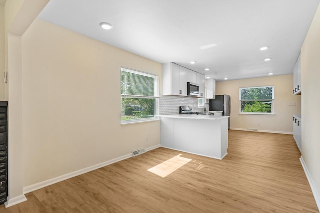 1345 E Deshler Ave, Columbus, OH 43206 - kitchen with a peninsula, light wood finished floors, appliances with stainless steel finishes, light countertops, and recessed lighting