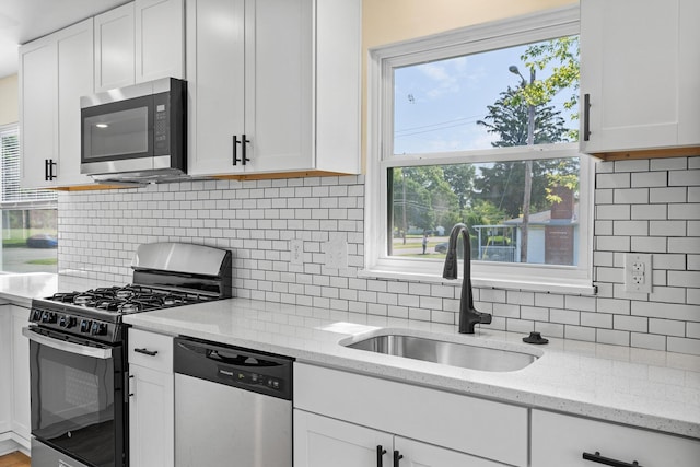 1345 E Deshler Ave, Columbus, OH 43206 - kitchen with stainless steel appliances, a sink, backsplash, and white cabinetry