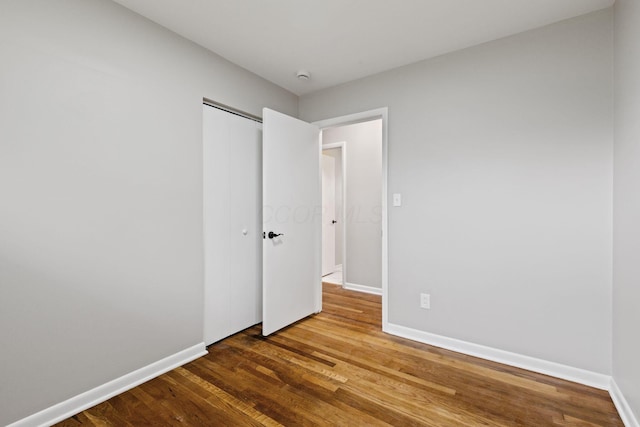 1001 S Harris Ave, Columbus, OH 43204 - unfurnished bedroom with wood finished floors, baseboards, and a closet