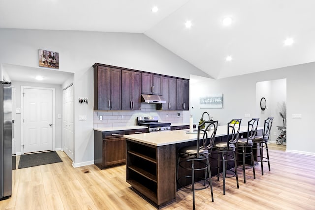 1333 Andy Way, Pataskala, OH 43062 - kitchen with appliances with stainless steel finishes, under cabinet range hood, light countertops, a breakfast bar area, and a kitchen island with sink