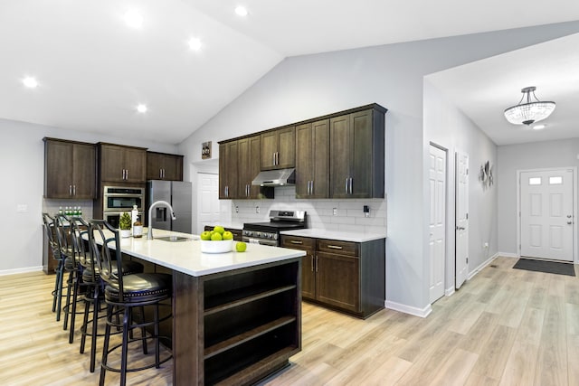 1333 Andy Way, Pataskala, OH 43062 - kitchen featuring appliances with stainless steel finishes, under cabinet range hood, dark brown cabinetry, a breakfast bar area, and light countertops