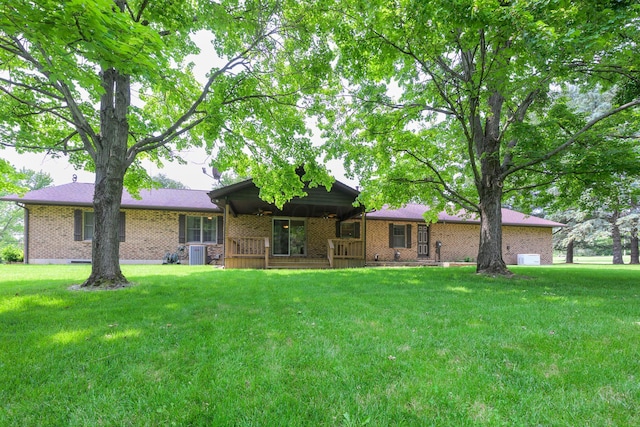 20 Snider Rd, New Carlisle, OH 45344 - back of property featuring a lawn, brick siding, central AC, and covered porch