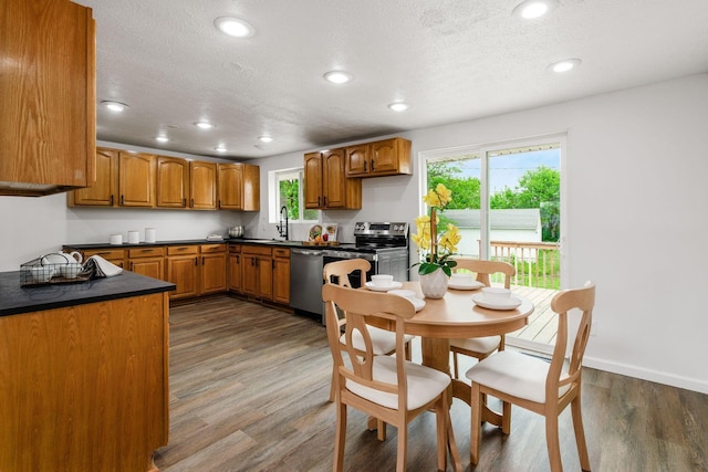 3944 Ardath Rd, Columbus, OH 43228 - kitchen with appliances with stainless steel finishes, dark countertops, brown cabinetry, plenty of natural light, and recessed lighting