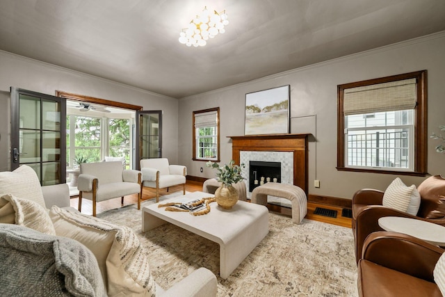 137 E Torrence Rd, Columbus, OH 43214 - living area with light wood-style flooring, a tiled fireplace, crown molding, and baseboards