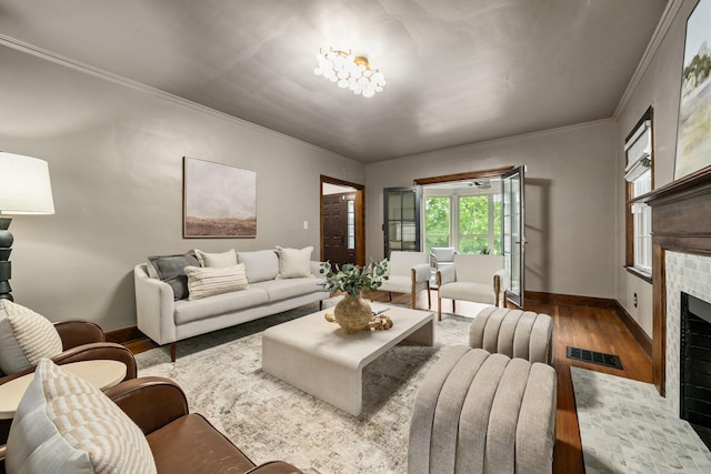 137 E Torrence Rd, Columbus, OH 43214 - living room with wood finished floors, a fireplace with flush hearth, baseboards, ornamental molding, and a chandelier