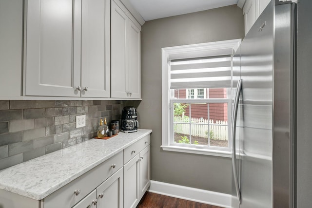 137 E Torrence Rd, Columbus, OH 43214 - kitchen featuring freestanding refrigerator, baseboards, backsplash, dark wood-style floors, and light stone counters