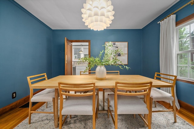 137 E Torrence Rd, Columbus, OH 43214 - dining space with healthy amount of natural light, baseboards, wood finished floors, crown molding, and a chandelier
